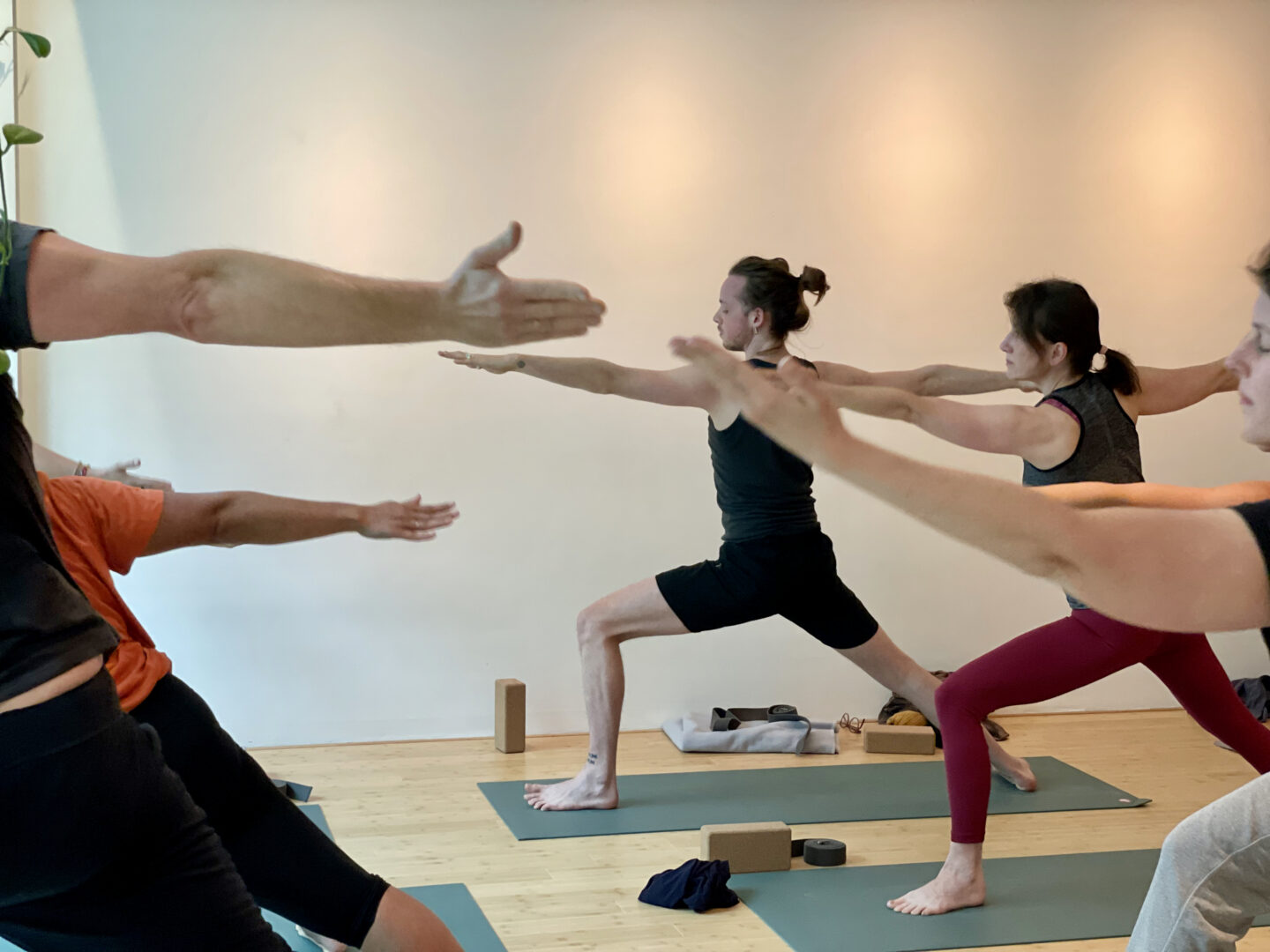 Deelnemers oefenen een staande yogahouding